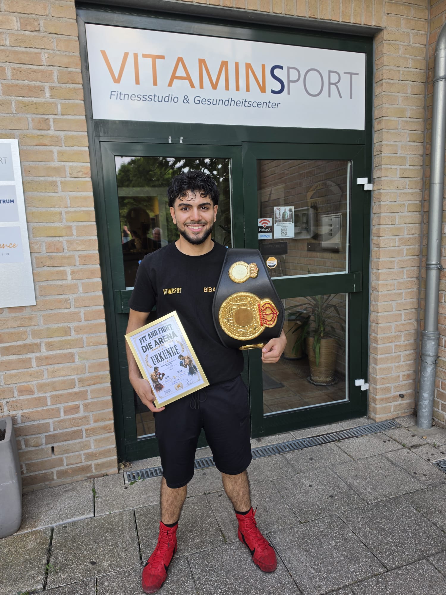 Bibars Ibrahim mit WBO-Meistergürtel und Siegerurkunde vor dem VITAMINSPORT